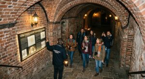 A cinematic, high-angle editorial photograph of a group of curious tourists exploring a dimly lit, h
