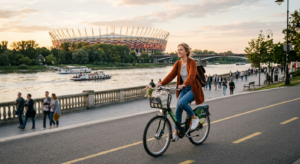 A high-quality, editorial-style photograph of a person riding a city bike along the Vistula river bo